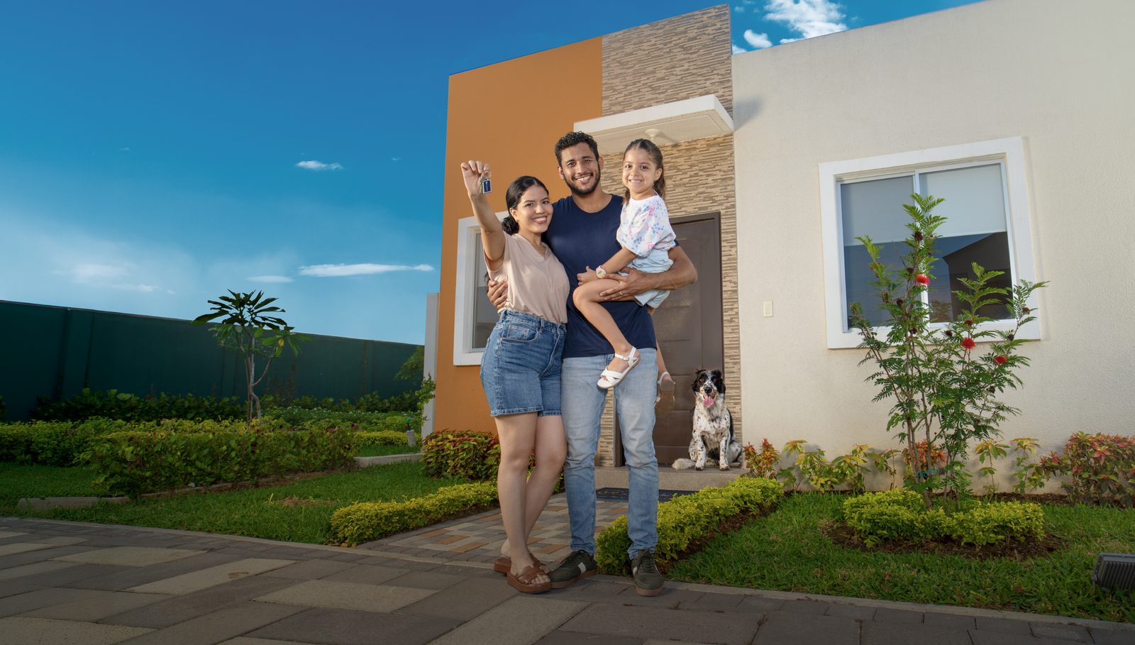 Familia ecuatoriana frente a su nueva vivienda