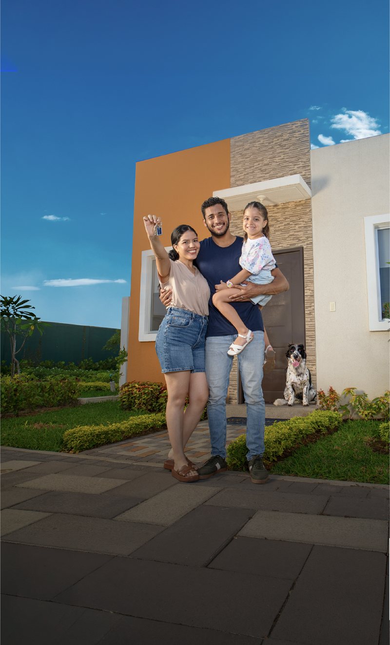 Familia ecuatoriana frente a su nueva vivienda